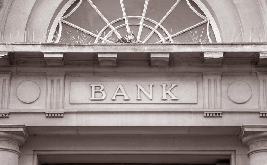 bank-sign-over-entrance-door-in-black-and-white-sepia-tone