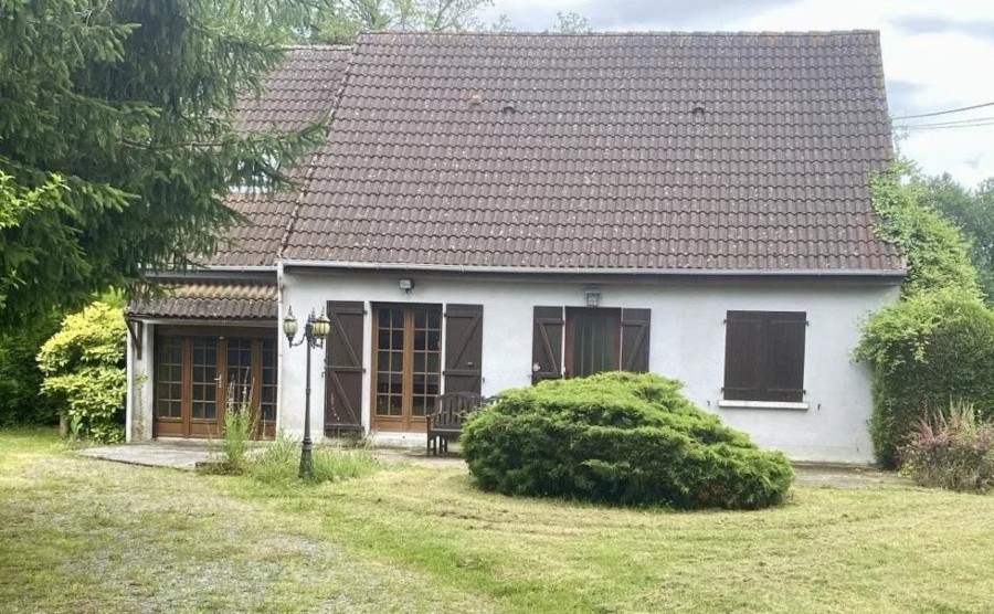 A charming property in the French countryside with wooden doors and brown shutters. 