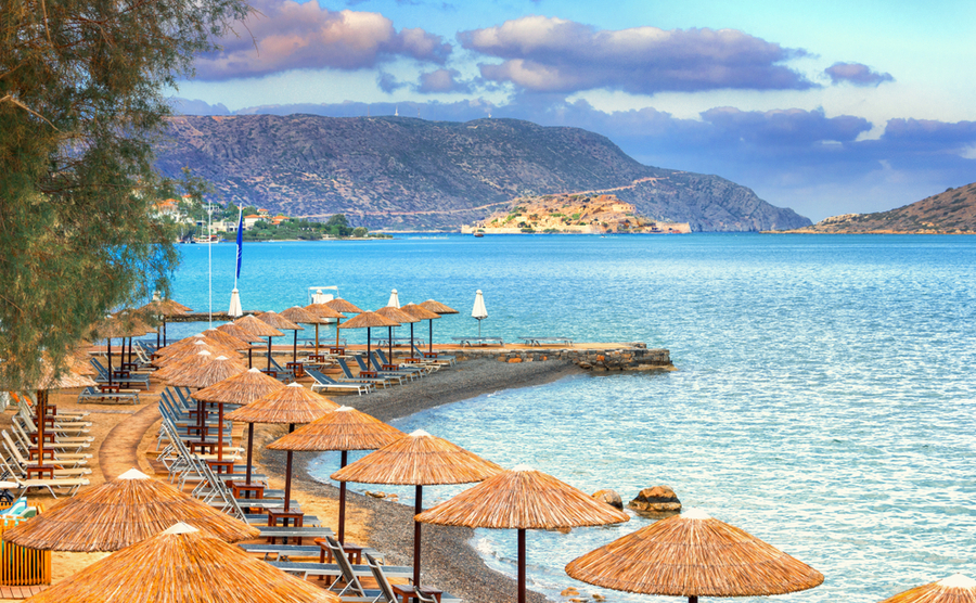 Panoramic view of the gulf of Elounda with the famous village of Elounda and the island of Spinalonga at sunset with nice clouds and calm sea, Crete, Greece.