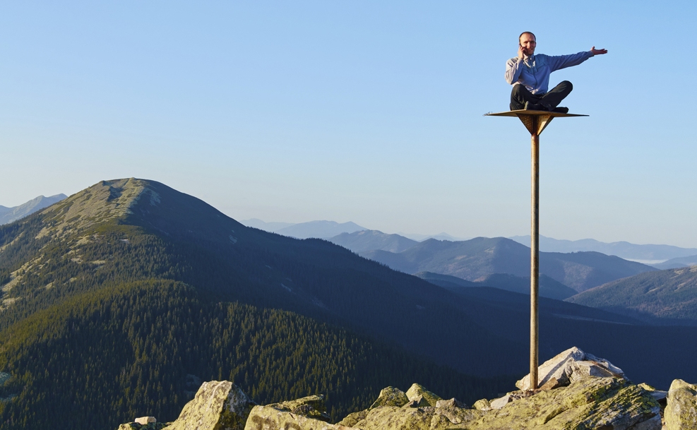 Man sitting on pole