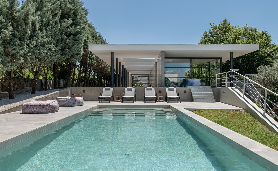 front of a modern villa with a pool.