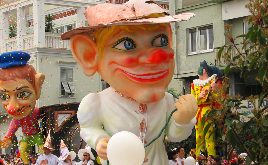 carinval float of a strange-looking man with a hat.