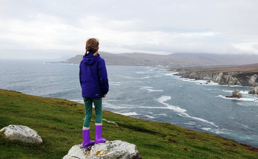 girl-standing-on-a-stone-in-the-background-dramatic-coastline-of-achill-island-county-mayo-ireland