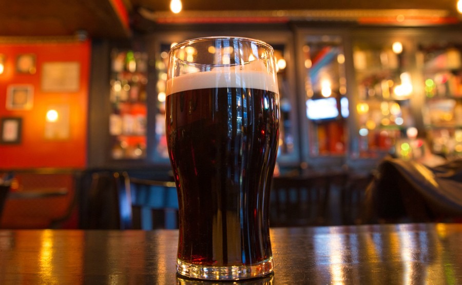 glass-of-dark-beer-with-candle-in-pub-setting
