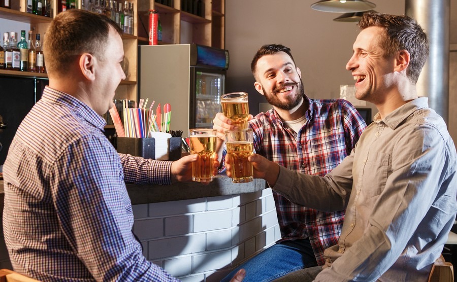 happy-friends-drinking-beer-at-counter-in-pub