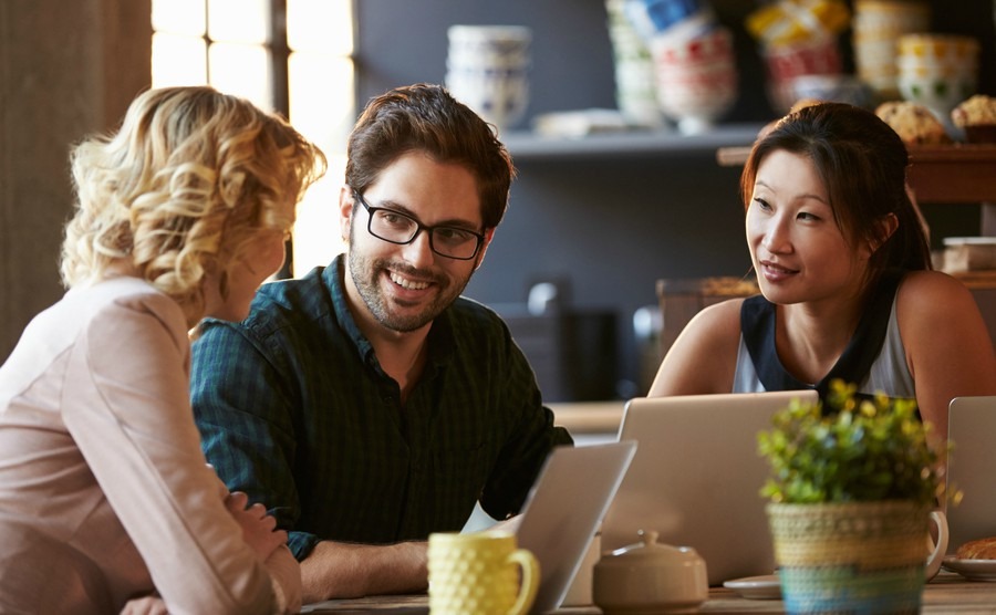 three-businesspeople-working-at-laptop-in-cafe