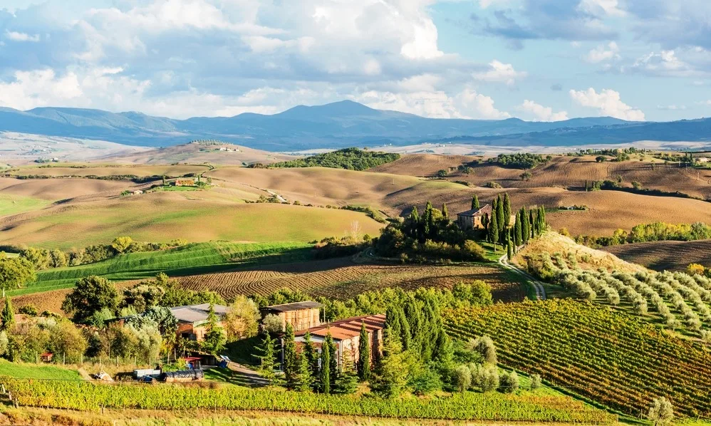 gladiator-fields-in-val-dorcia-tuscany-italy-scenic-landscape-with-farmhouse-amidst-rolling-hills-and-valleys