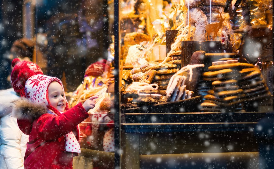 children-window-shopping-on-traditional-christmas-market-in-germany-on-snowy-winter-day-kids-buying-candy-pastry-and-gingerbread-in-confectionery-boy-and-girl-choosing-sweets-in-xmas-bakery