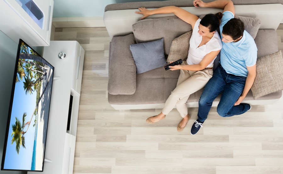 high-angle-view-of-young-couple-watching-movie-on-television-at-home