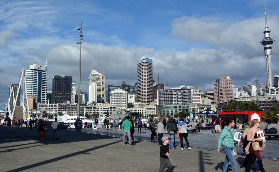 visitors-walks-at-wynyard-quarter-against-auckland-skyline-new-zealand-auckland-is-one-of-the-most-ethnically-diverse-cities-in-the-world