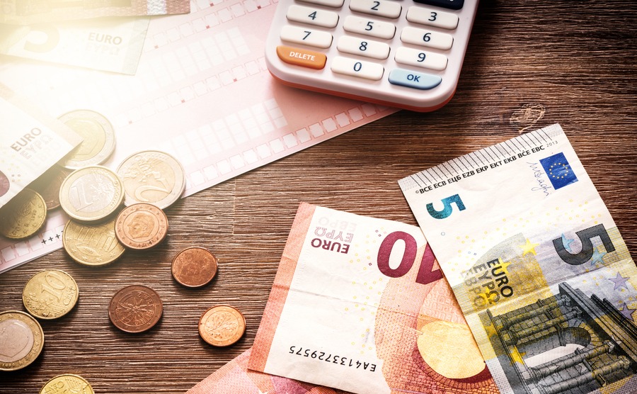 Euro banknotes and coins with bills to pay. Finances and budget concept