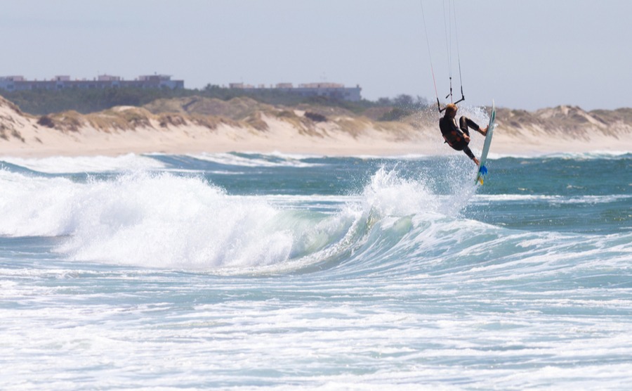 man jumps on kite surf board sea waves in Cabedelo Beach, Viana do Castelo, Portugal.