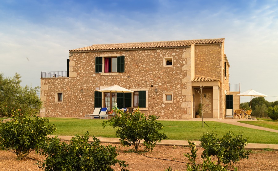 CAMPOS, MALLORCA, SPAIN - August 30, 2017: Old Mediterranean finca, buildings built in traditional island style and garden with orange trees in front,. Balearic islands. Summer 2017.