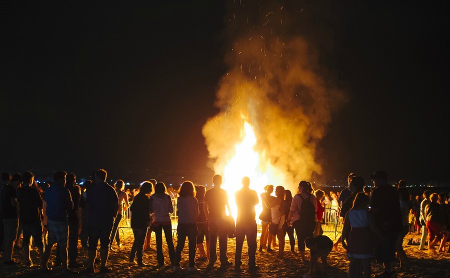 laredo-spain-june-24-2014-people-celebrate-st-johns-eve-around-a-bonfire-in-a-beach-in-northern-spain-st-johns-eve-celebration-around-a-bonfire-is-reminiscent-of-midsummers-pagan-rituals