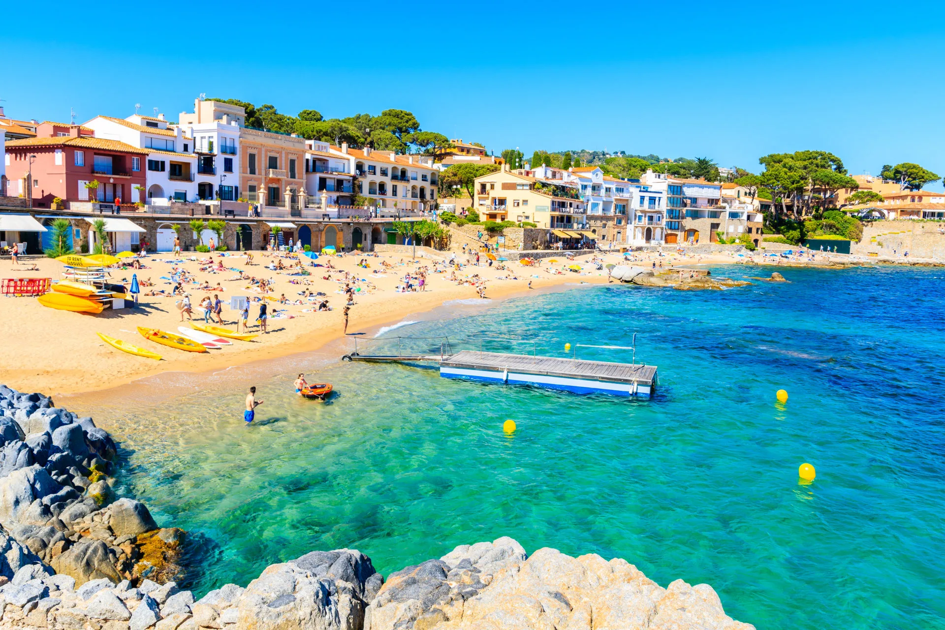 People in water on beach in village of Calella de Palafrugell, Costa Brava, Spain