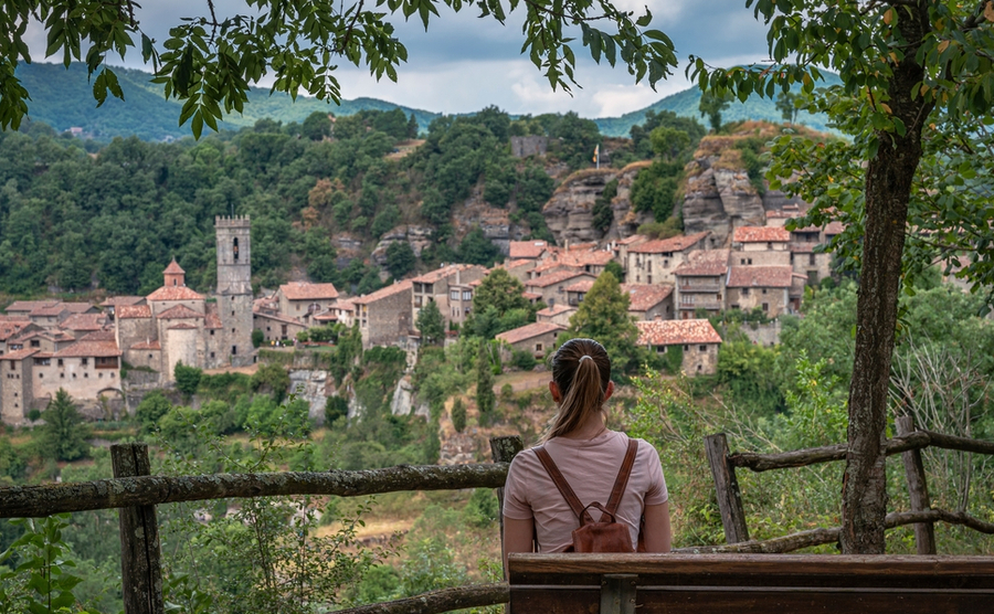 A woman looking out to Rupit from a bench. 