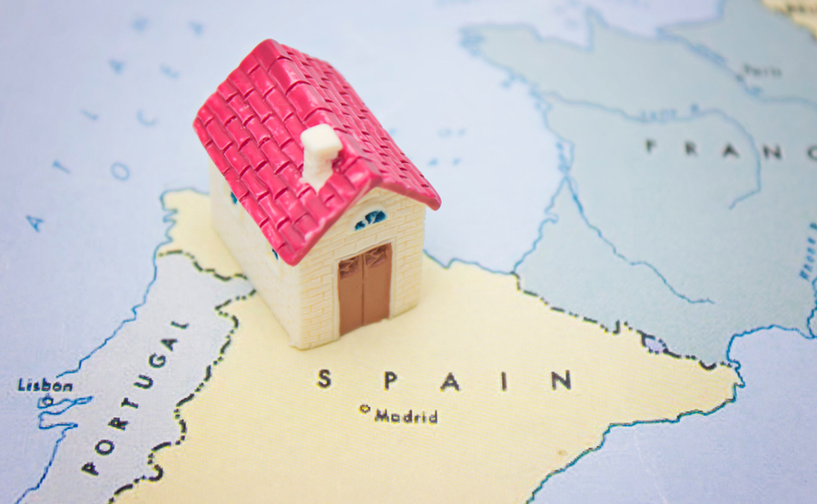 Figurine of a house on top of a map of Spain.